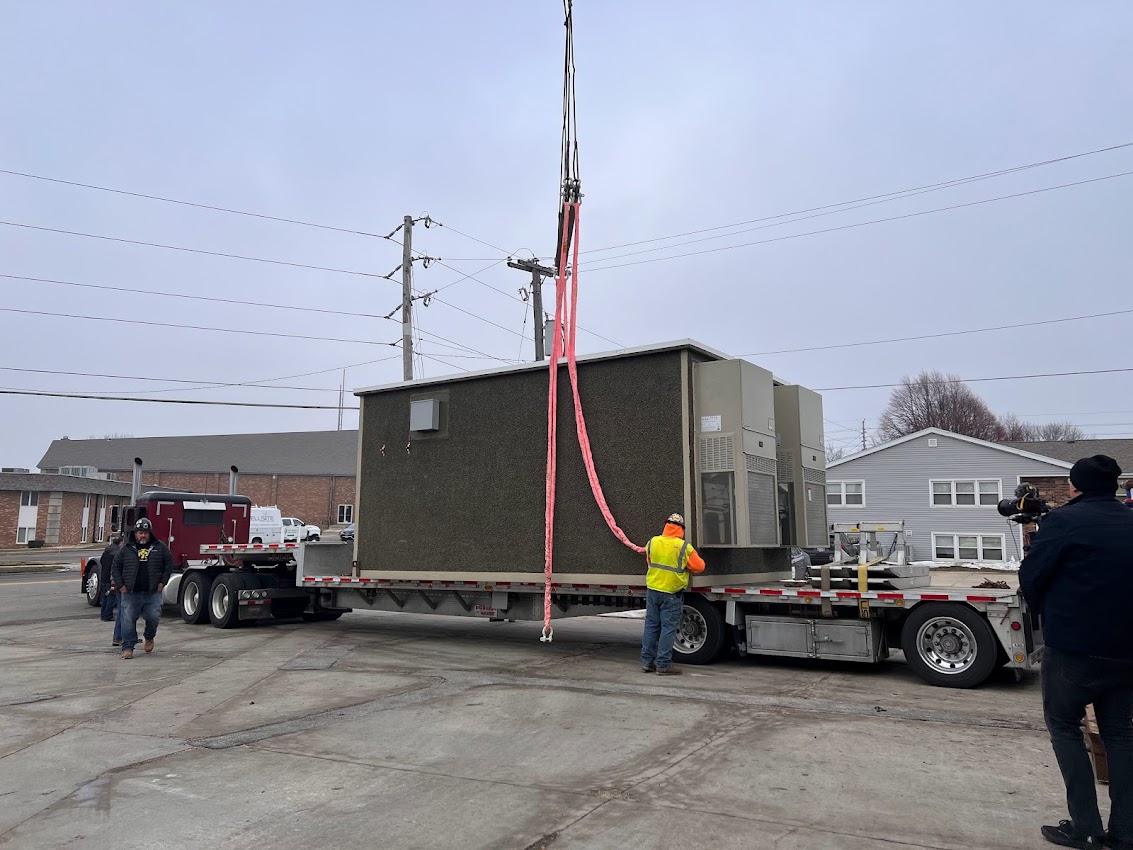 Crane lifting data center hut